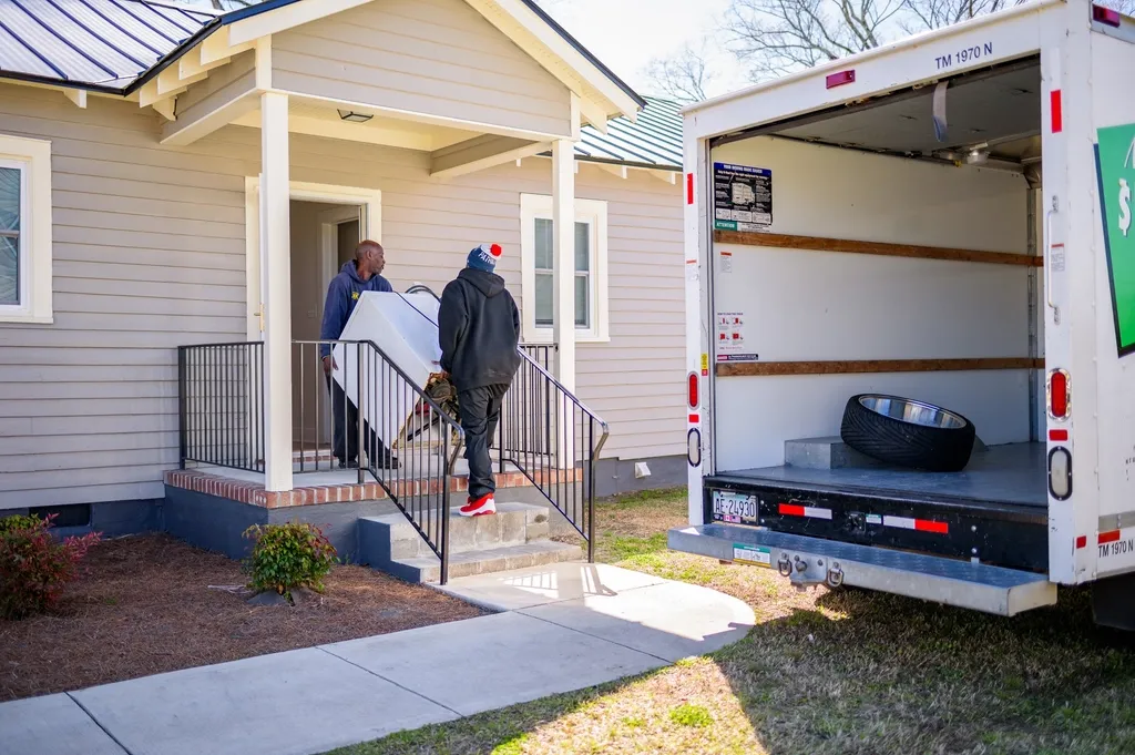 Movers unloading a moving truck at a house